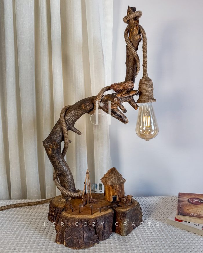 Hook Rise Lamp — Slender branch lifting light over rustic yard